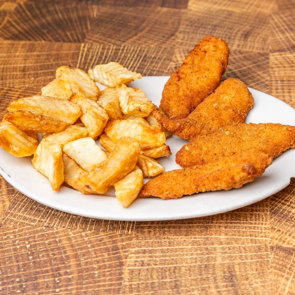 A white plate holds golden-brown chicken tenders and crispy waffle fries on a wooden table.