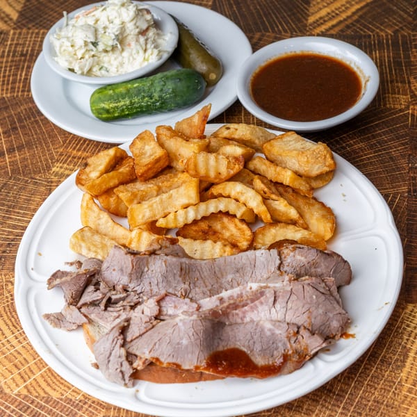 Pastrami Express roast beef sandwich with crinkle-cut fries, coleslaw, pickles, and dipping sauce.